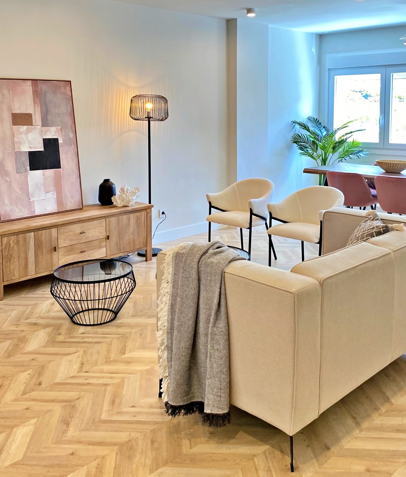 Sala de estar moderna con sofá claro, mesa baja y decoración minimalista.